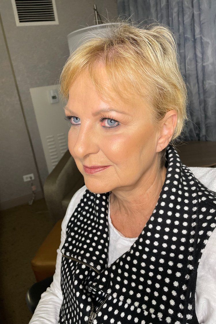 A close up of a woman wearing a black and white polka dot vest.