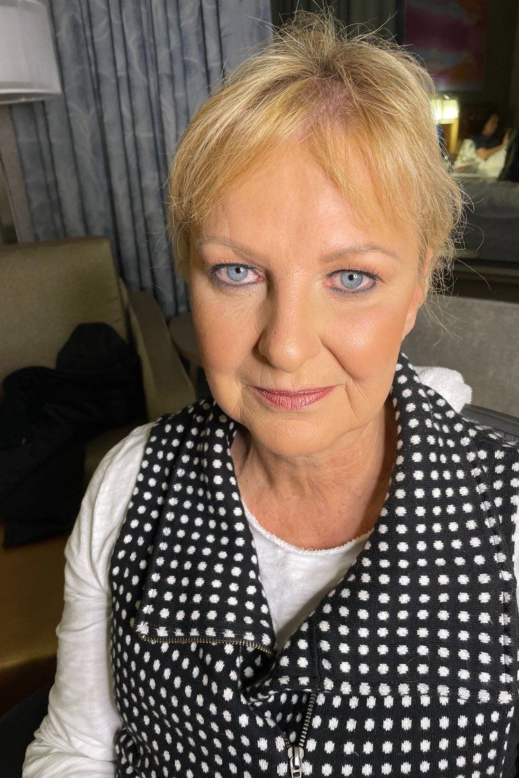 A close up of a woman wearing a black and white polka dot vest.