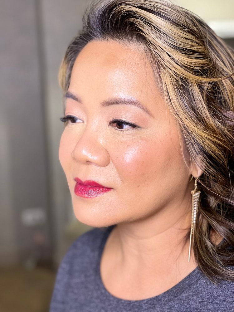 A close up of a woman 's face with red lipstick and earrings.