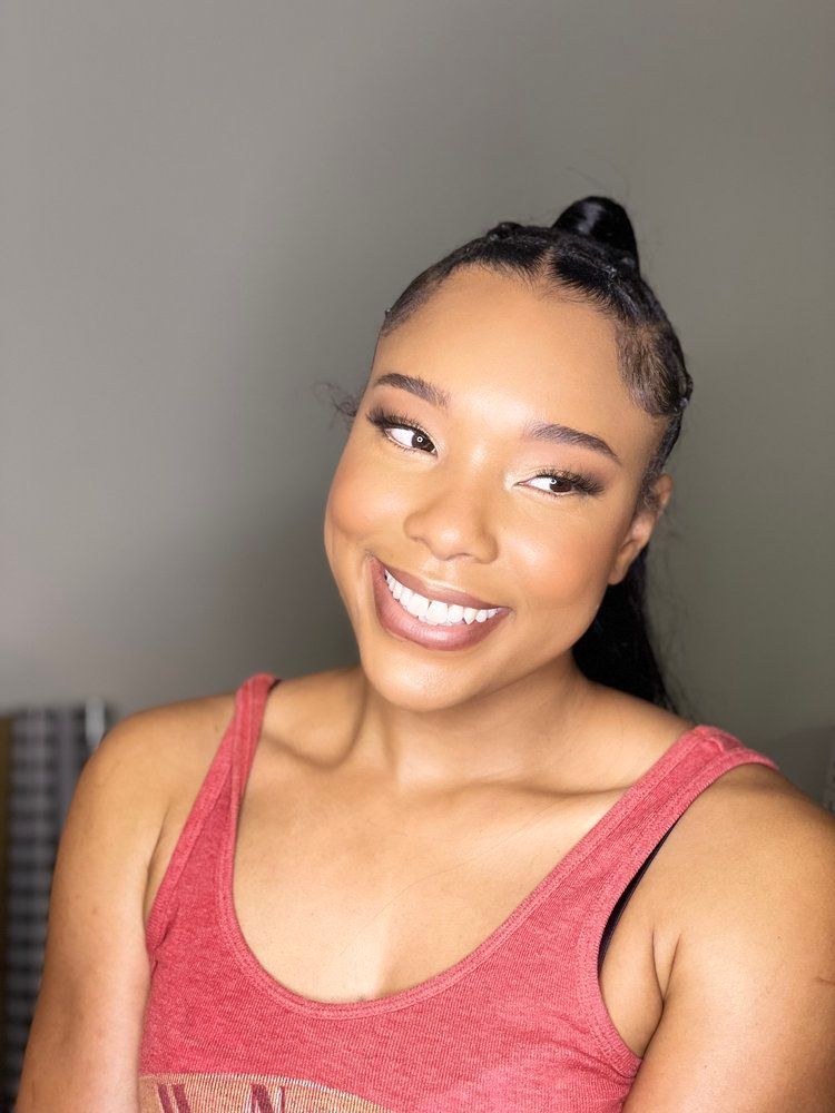 A woman in a red tank top is smiling for the camera.