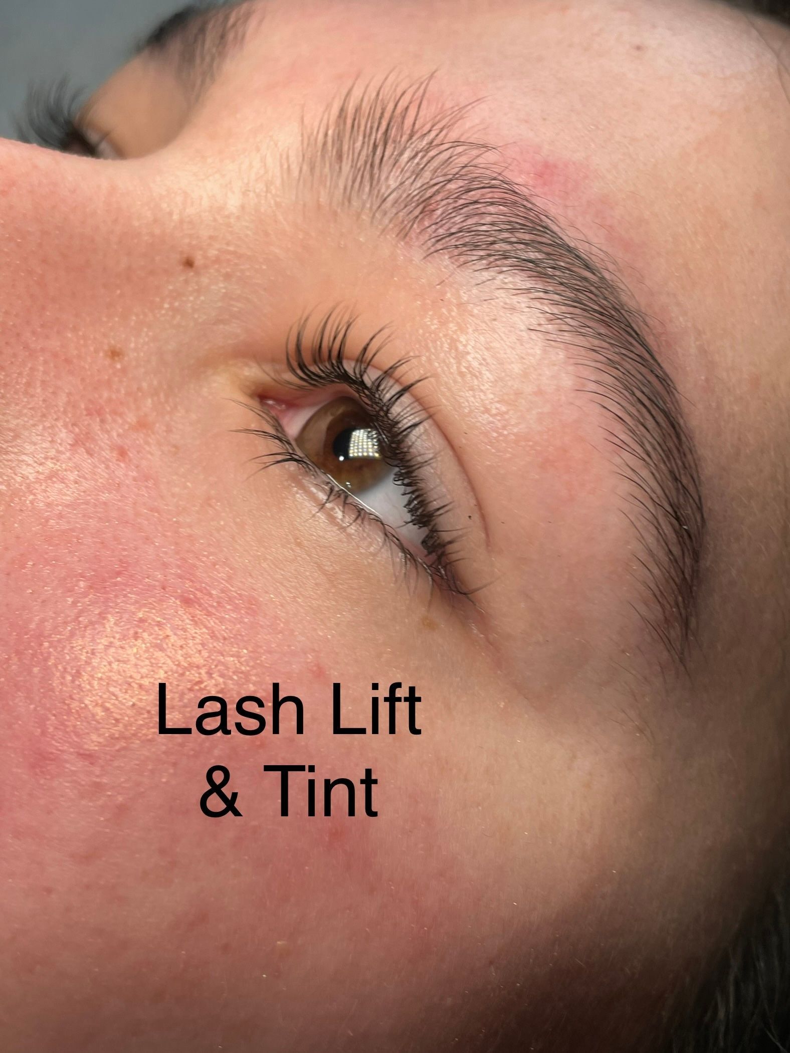 A close up of a woman 's face with a lash lift and tint.