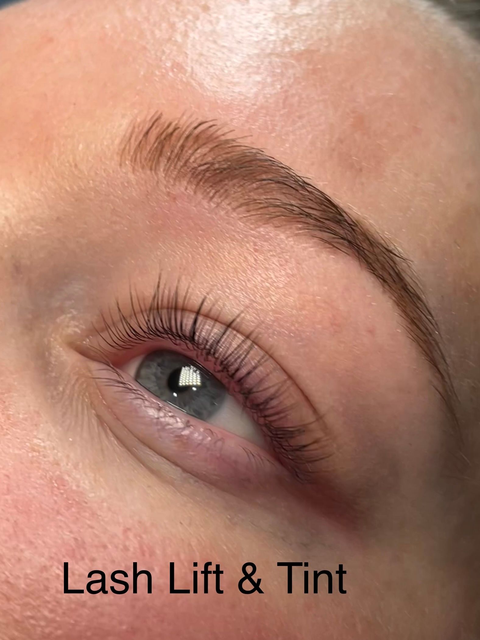 A close up of a woman 's eye with lash lift and tint.