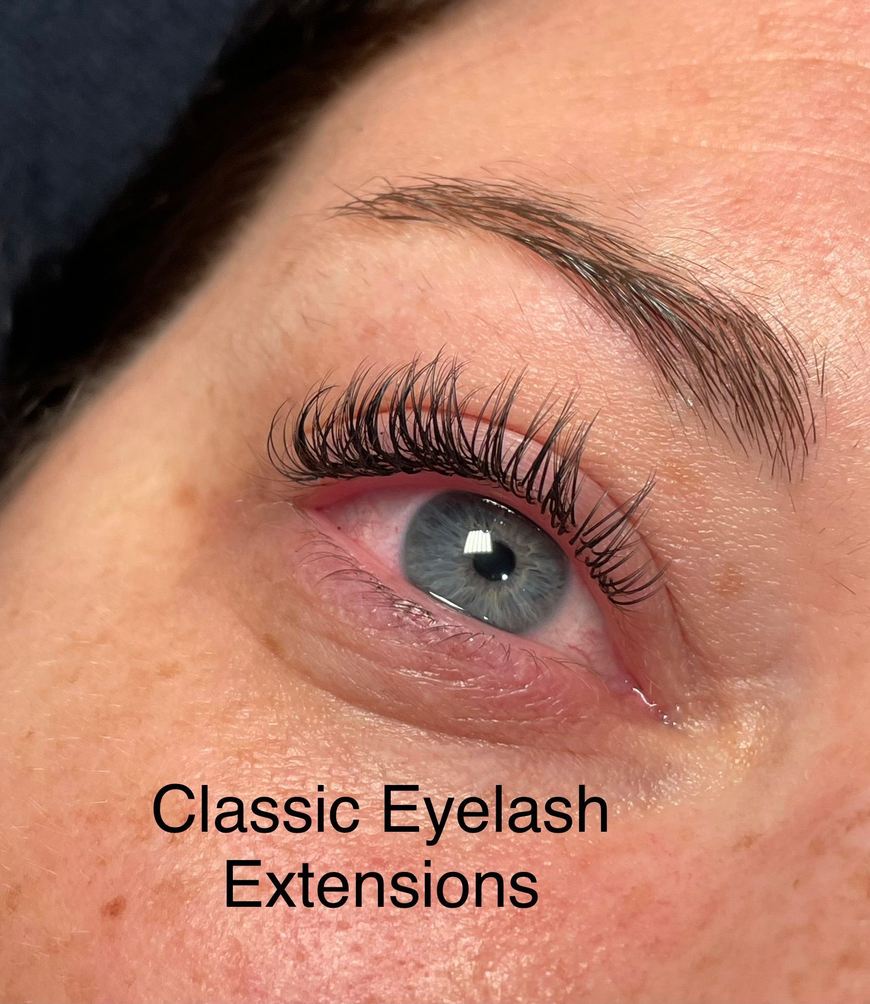 A close up of a woman 's eye with classic eyelash extensions