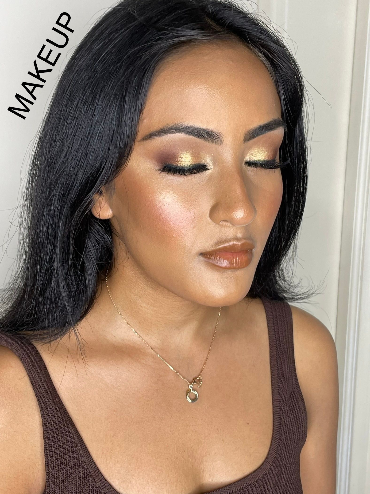 A woman is wearing makeup and a necklace.