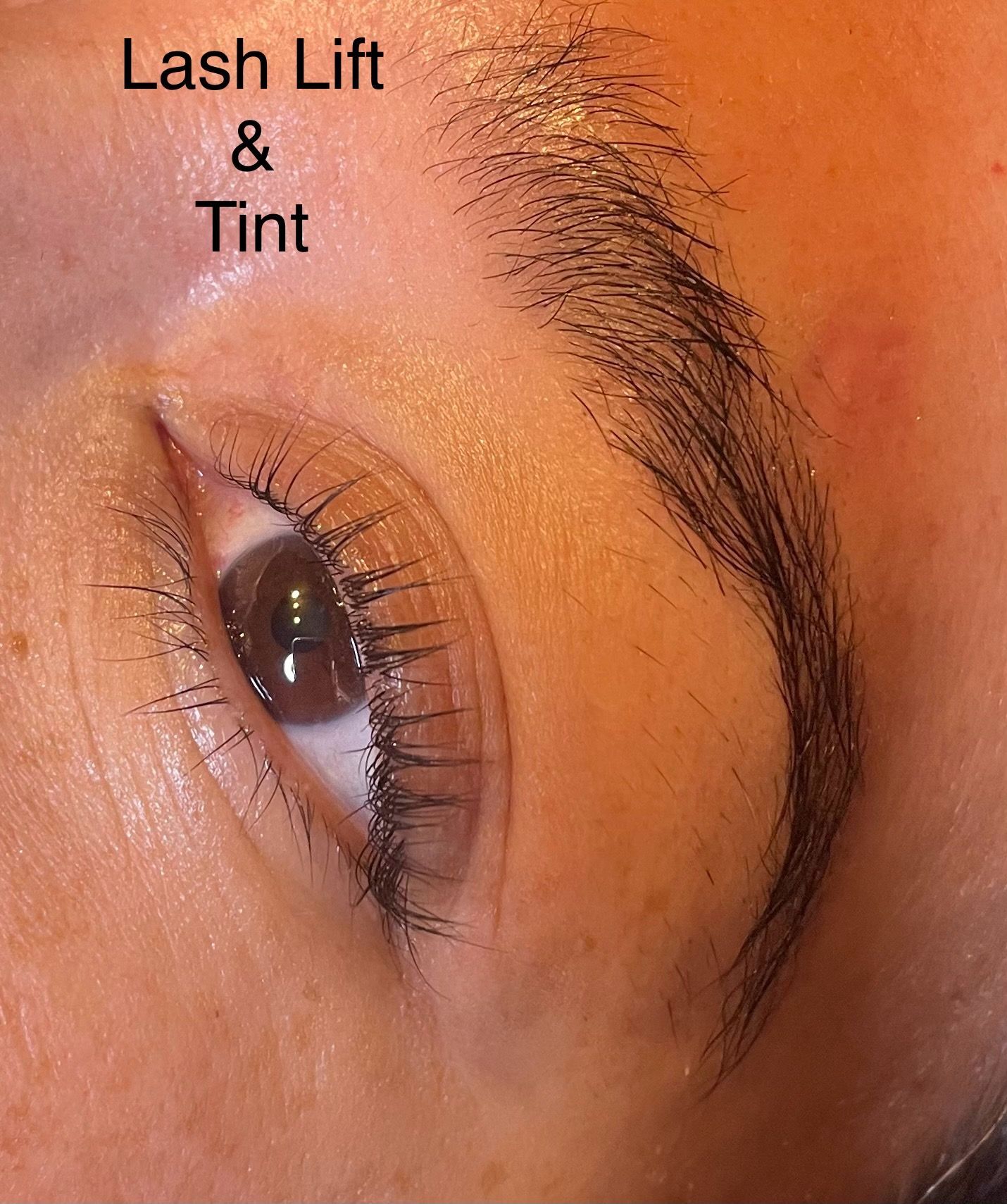 A close up of a woman 's eye with lash lift and tint