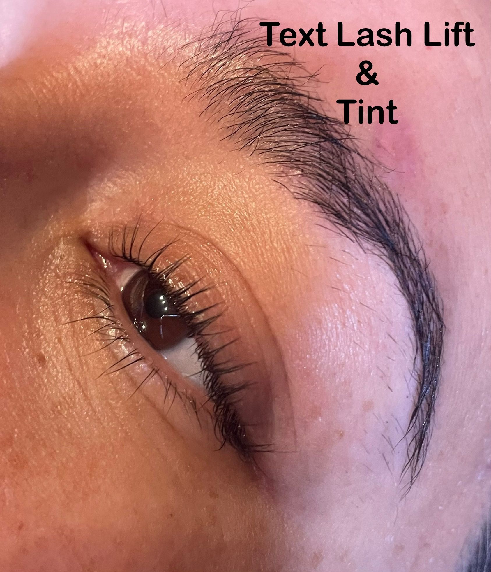 A close up of a woman 's eye with a text lash lift and tint.