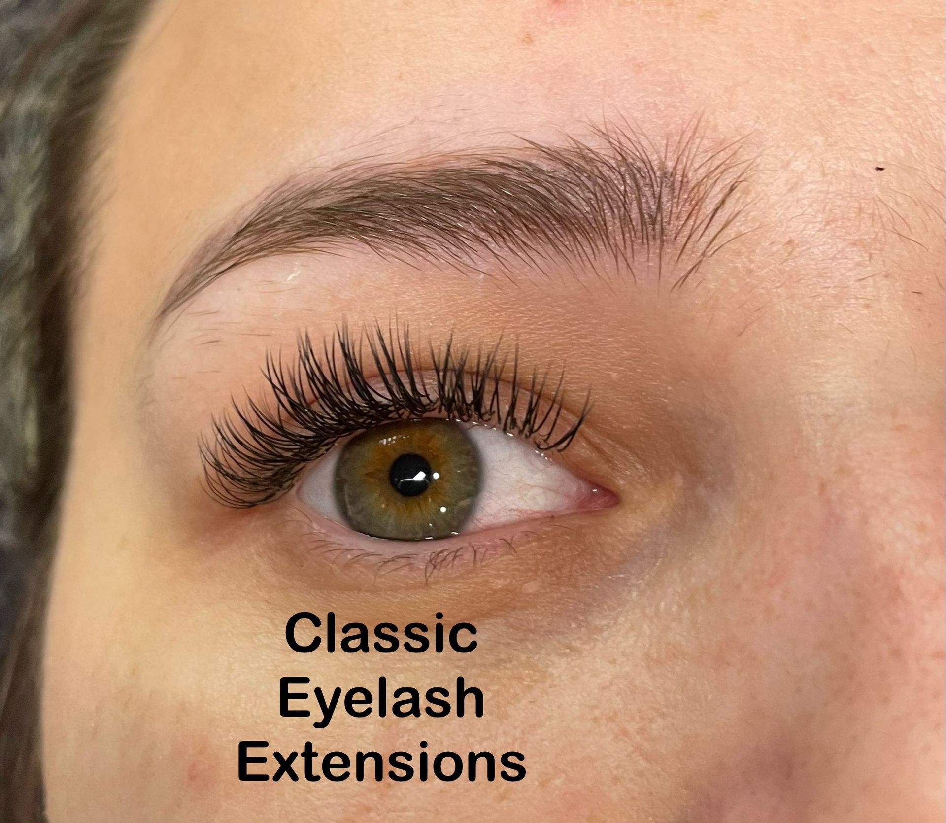 A close up of a woman 's eye with classic eyelash extensions.