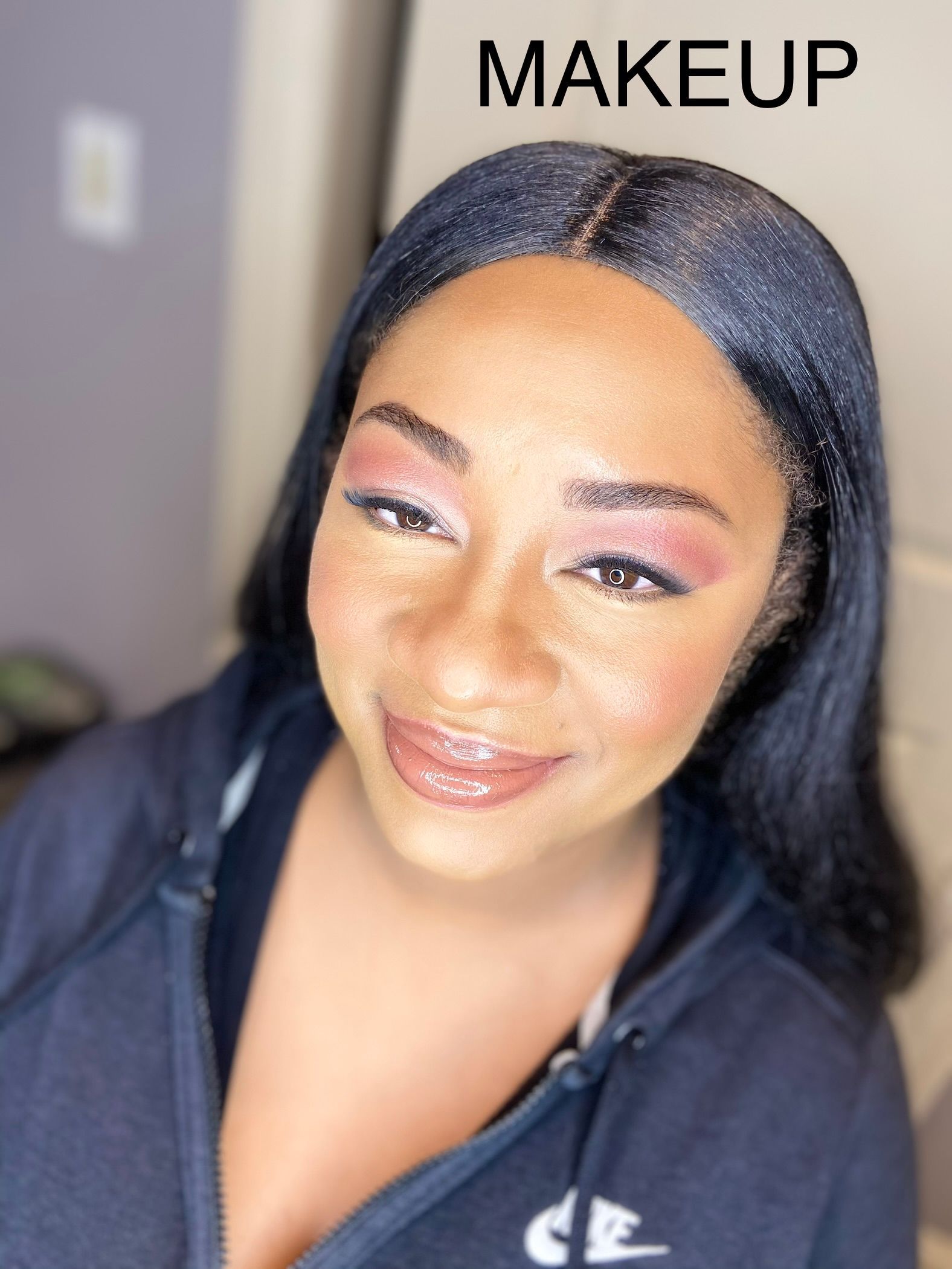 A woman wearing a nike hoodie has makeup on her face