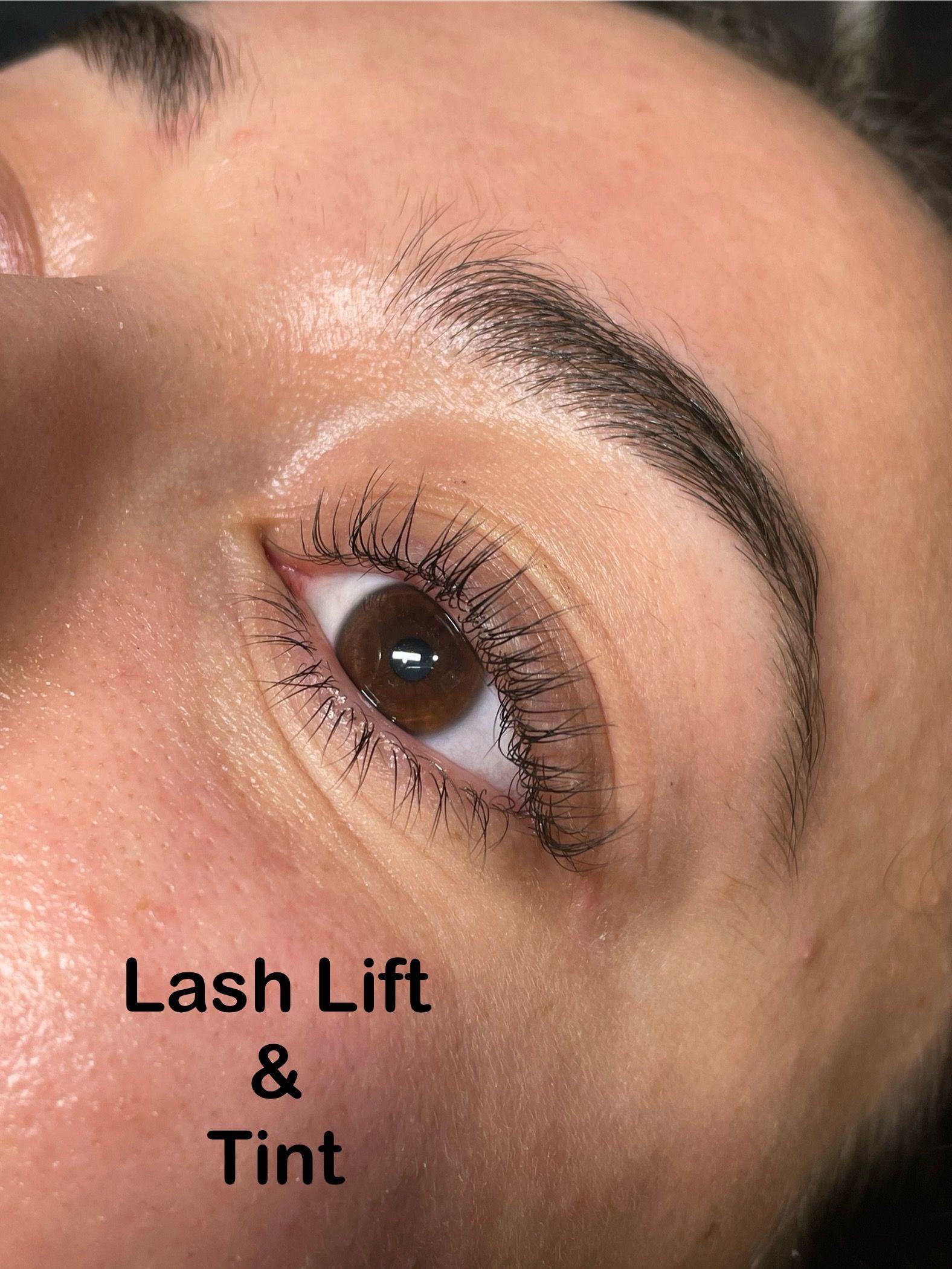 A close up of a woman 's eye with lash lift and tint.