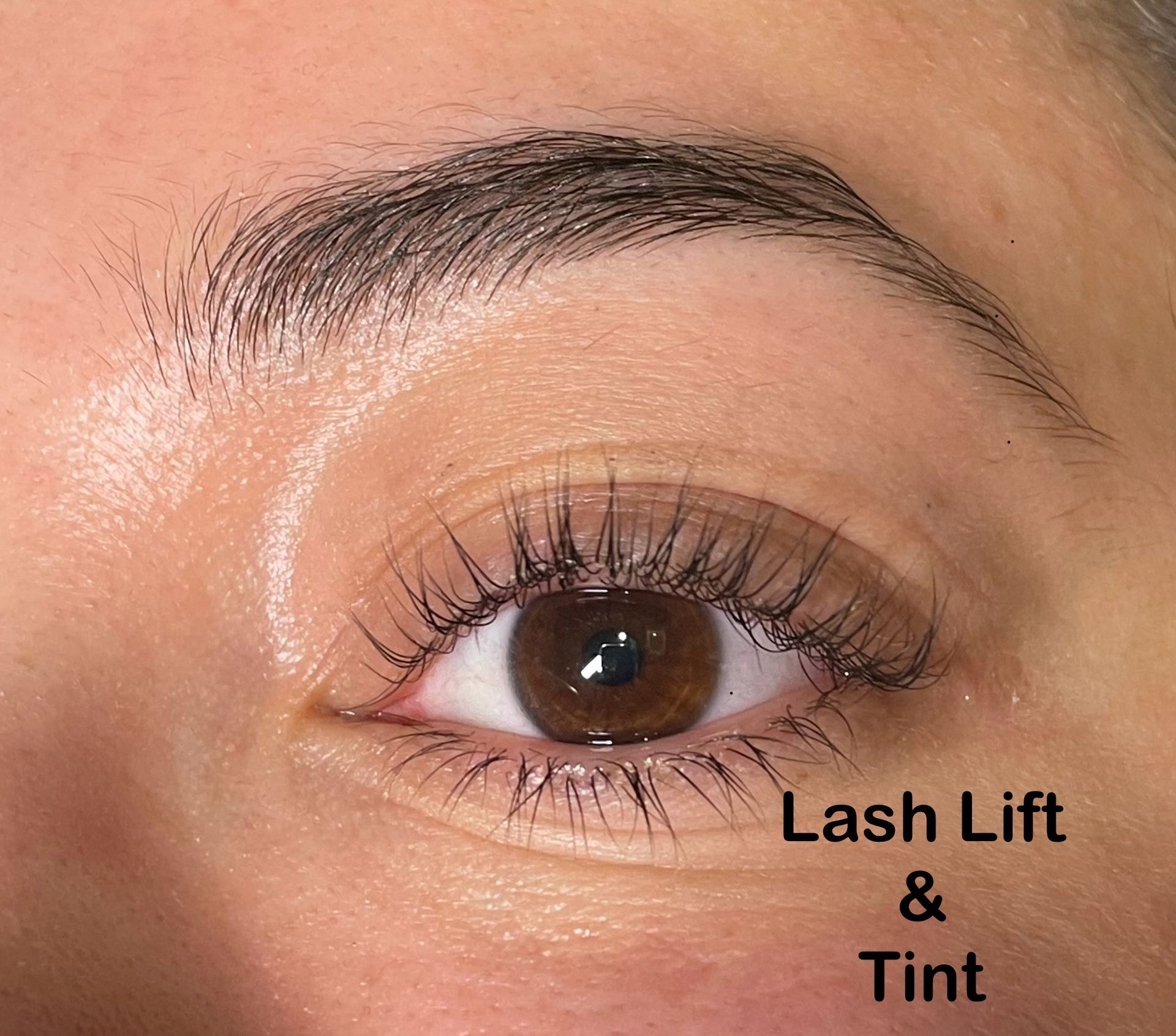 A close up of a woman 's eye with lash lift and tint