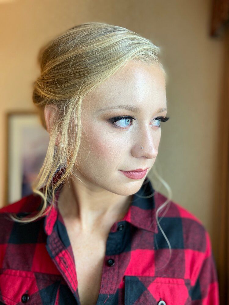 A woman in a plaid shirt is looking at the camera.