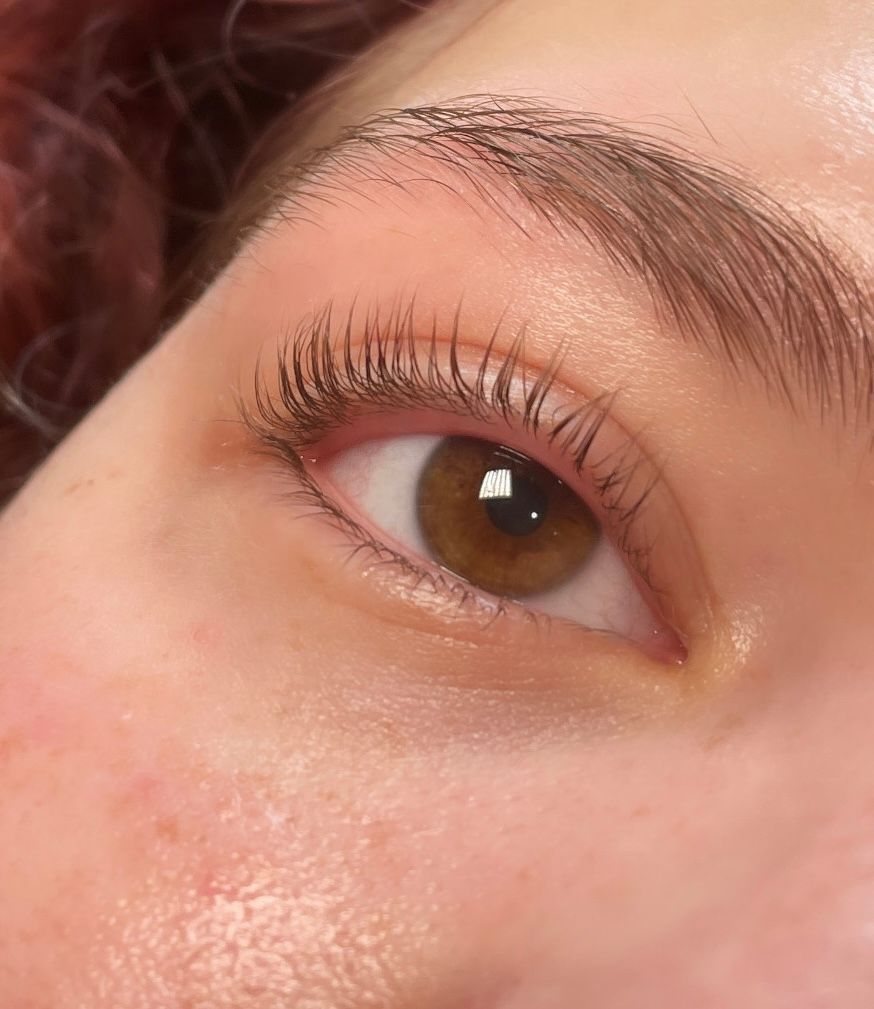 A close up of a woman 's eye with long eyelashes.