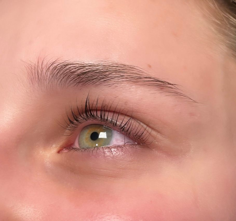 A close up of a woman 's eye with long eyelashes.