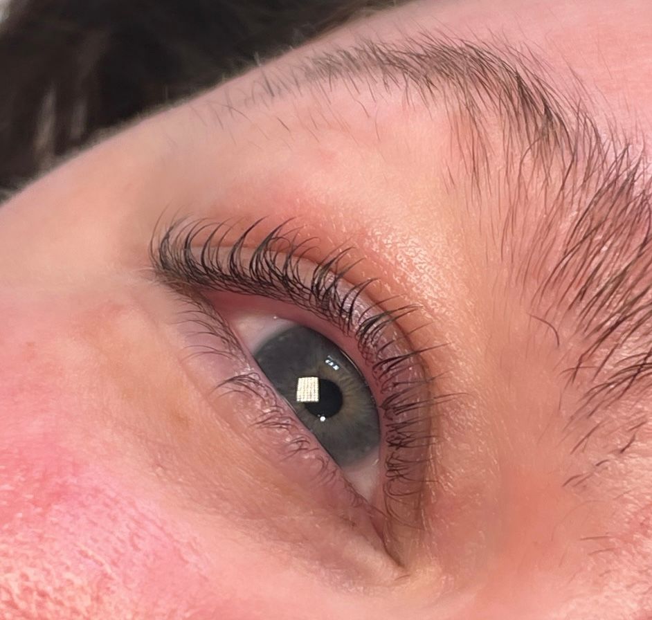 A close up of a woman 's eye with long eyelashes.