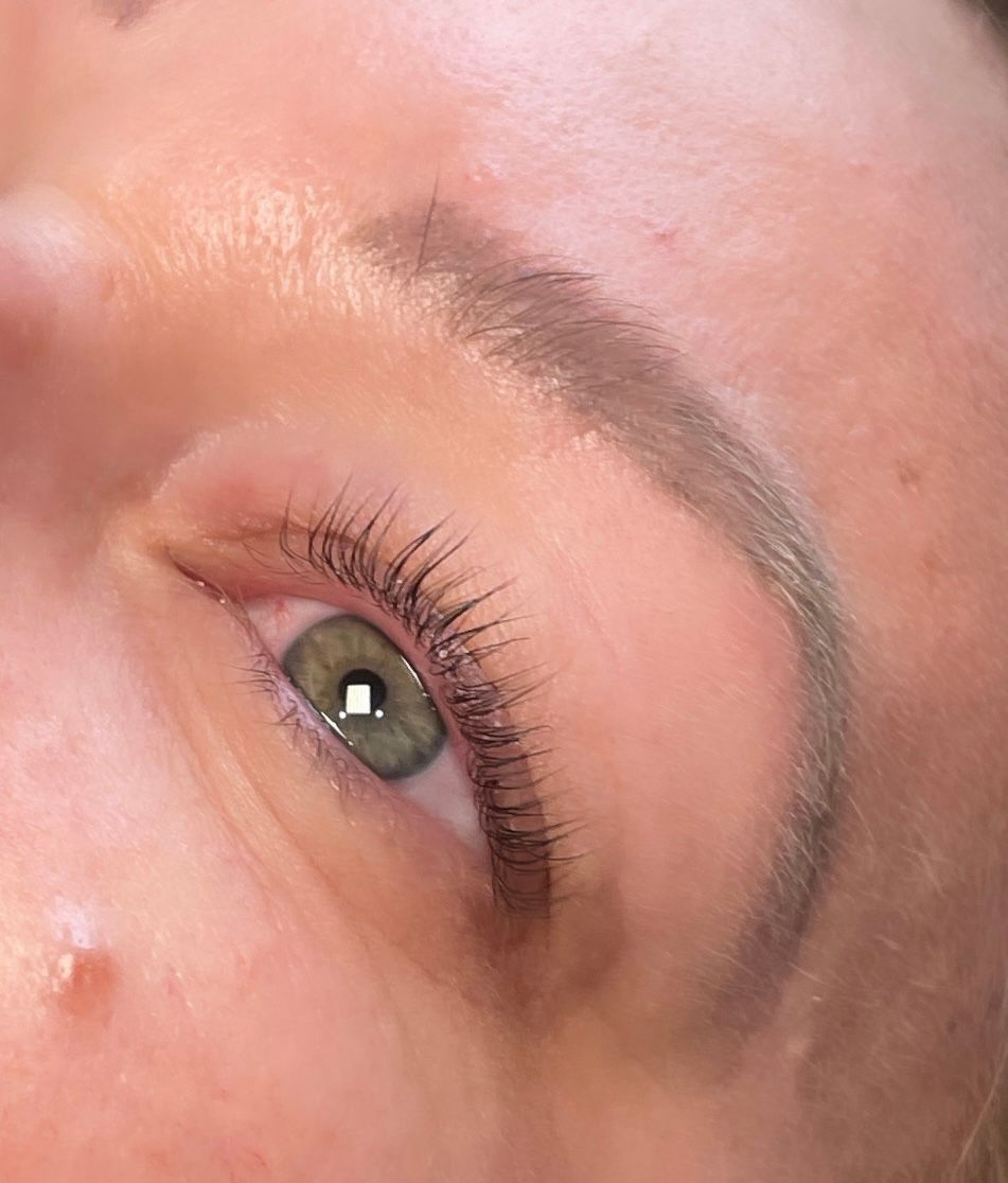 A close up of a woman 's eye with long eyelashes.