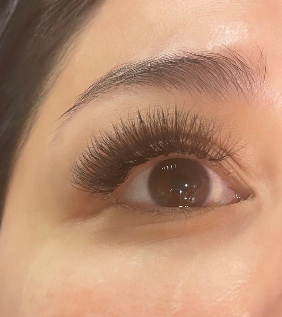 A close up of a woman 's eye with long eyelashes.