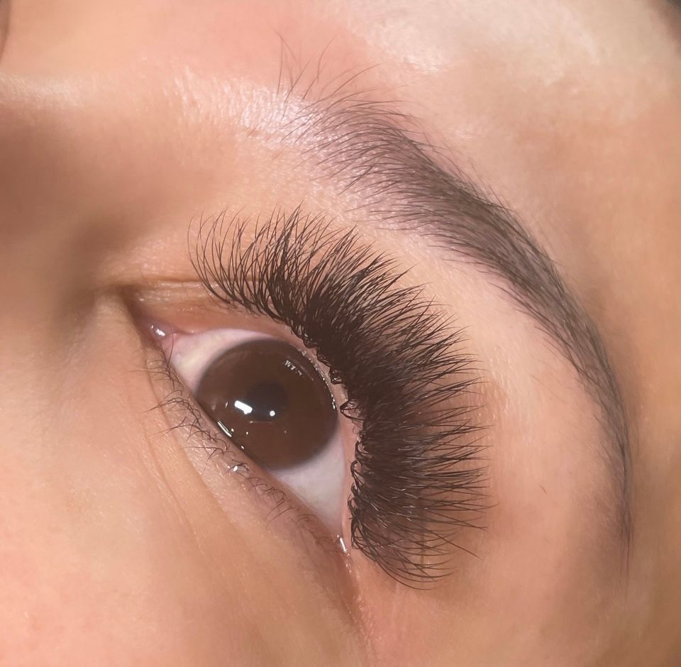 A close up of a woman 's eye with long eyelashes.