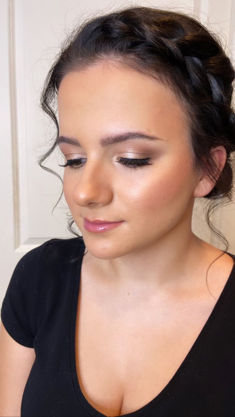 A woman is wearing a braided headband and a black shirt.