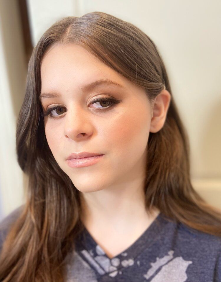 A close up of a woman 's face wearing a blue shirt