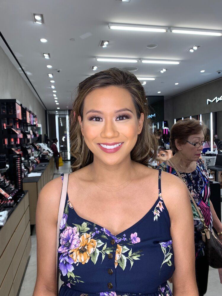 A woman in a floral dress is smiling in a store