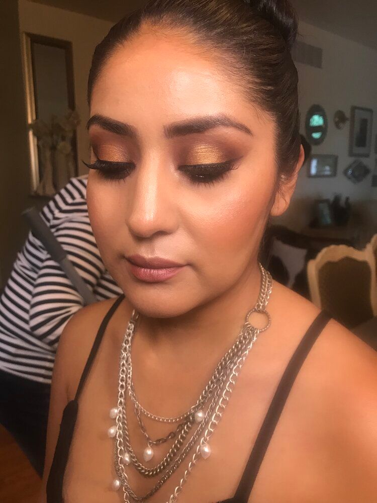 A woman is wearing a necklace and a bun.