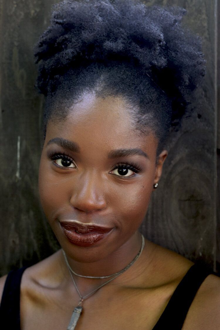 A close up of a woman 's face with a necklace around her neck.