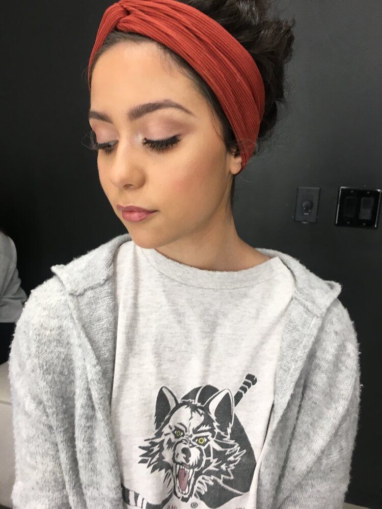 A woman wearing a headband and a t-shirt with a cat on it