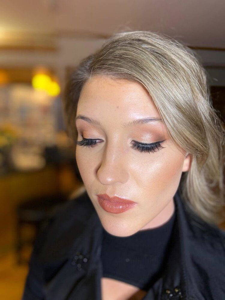 A close up of a woman wearing makeup and a black jacket.