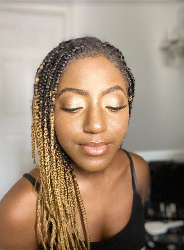 A woman with braids has her eyes closed