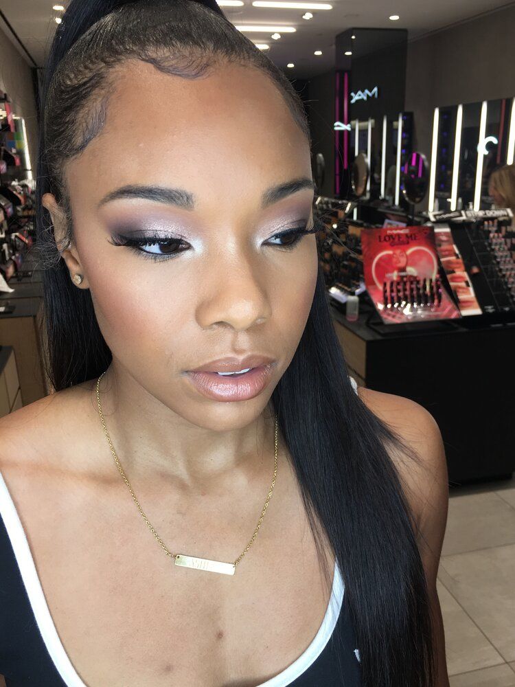 A woman is wearing a ponytail and a necklace in a store.