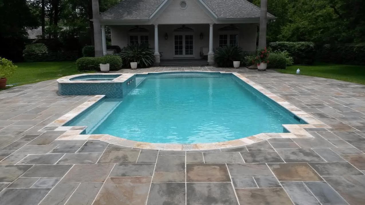 A large swimming pool with a house in the background