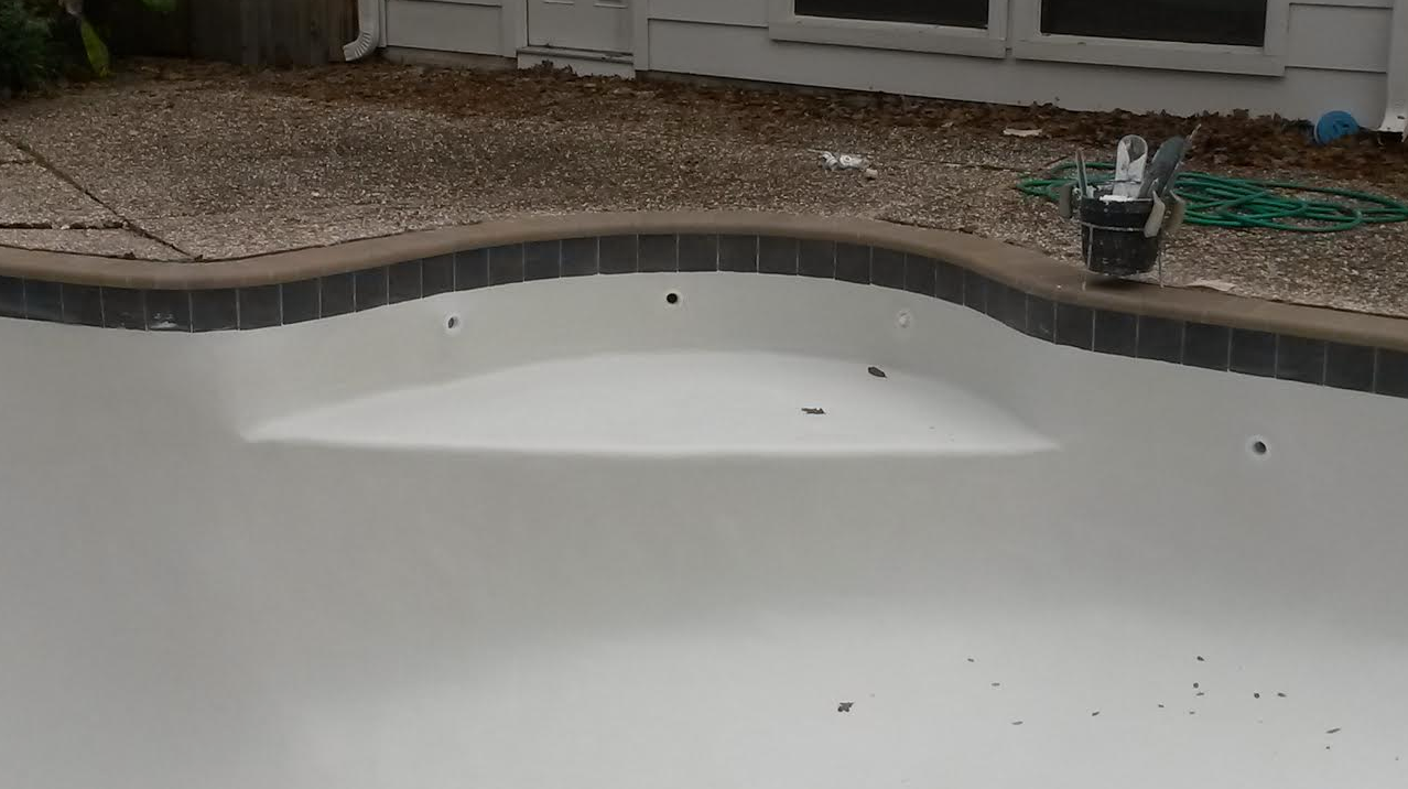 A swimming pool with a bucket on the edge of it.