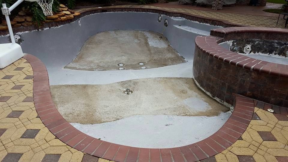 An empty swimming pool with a brick border around it