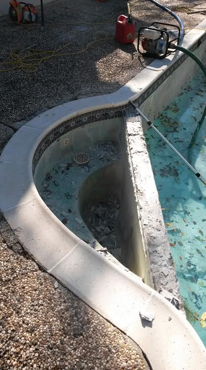 A swimming pool is being cleaned with a vacuum cleaner.