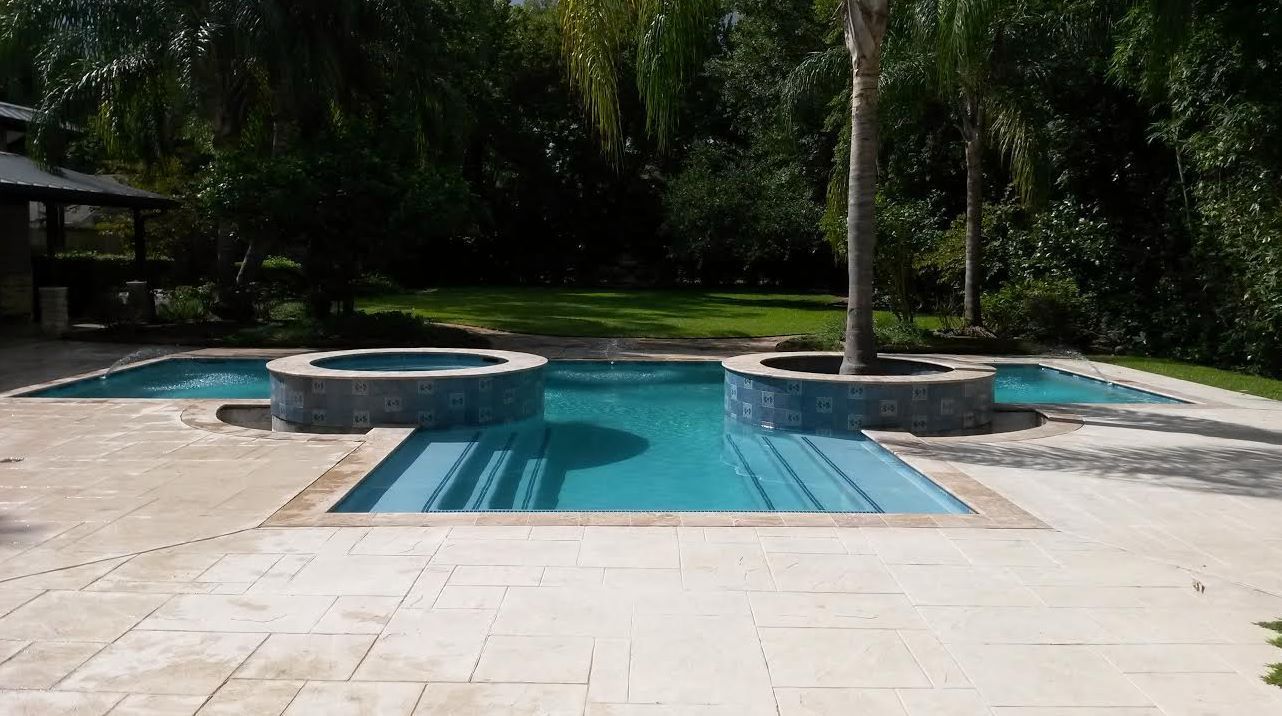 A large swimming pool with a hot tub in the middle