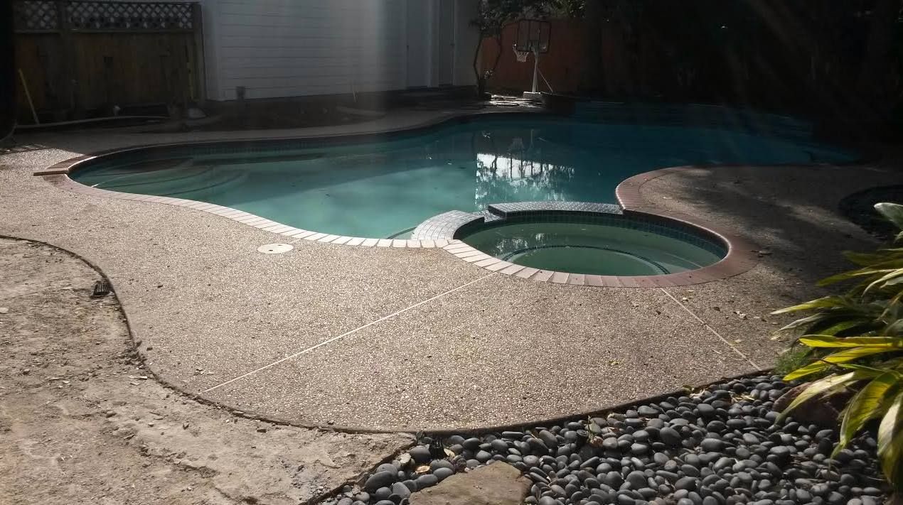 A swimming pool with a hot tub in the middle of it.