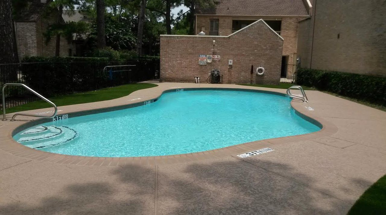 A large swimming pool in front of a brick building