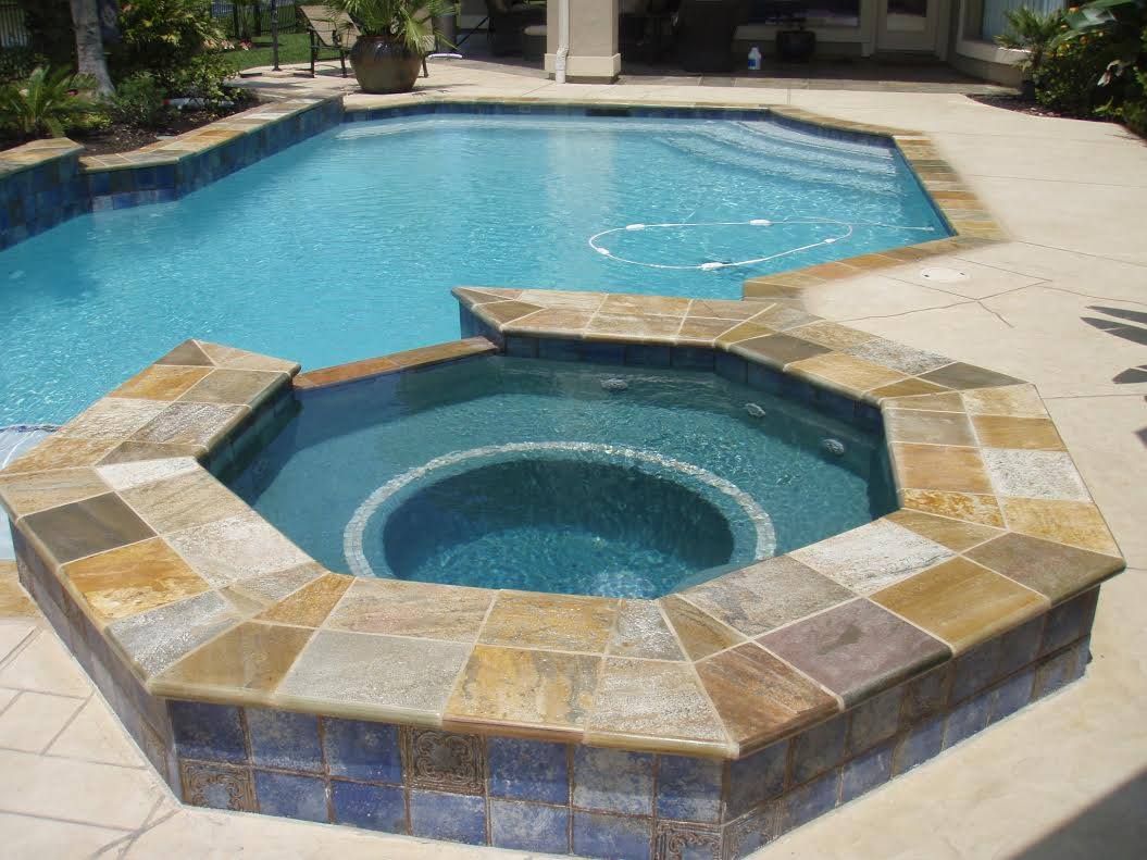 A swimming pool with a hot tub in the middle