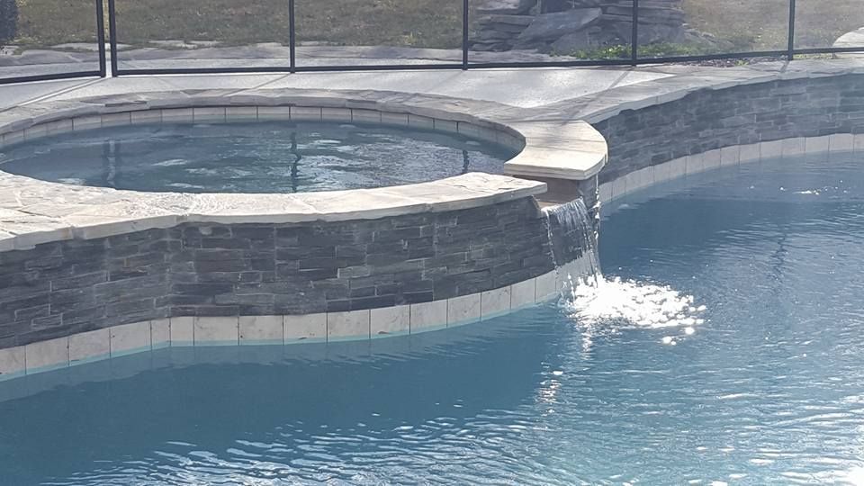 There is a waterfall in the middle of the pool.