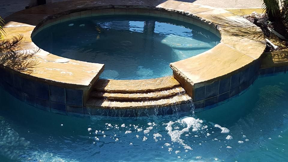 A swimming pool with a waterfall in the middle of it