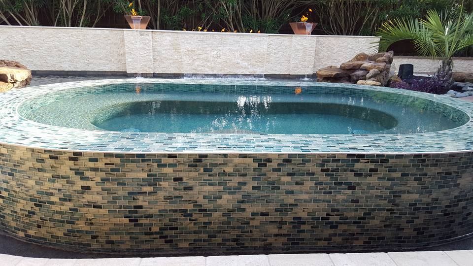 A large swimming pool with a fountain in the middle of it.