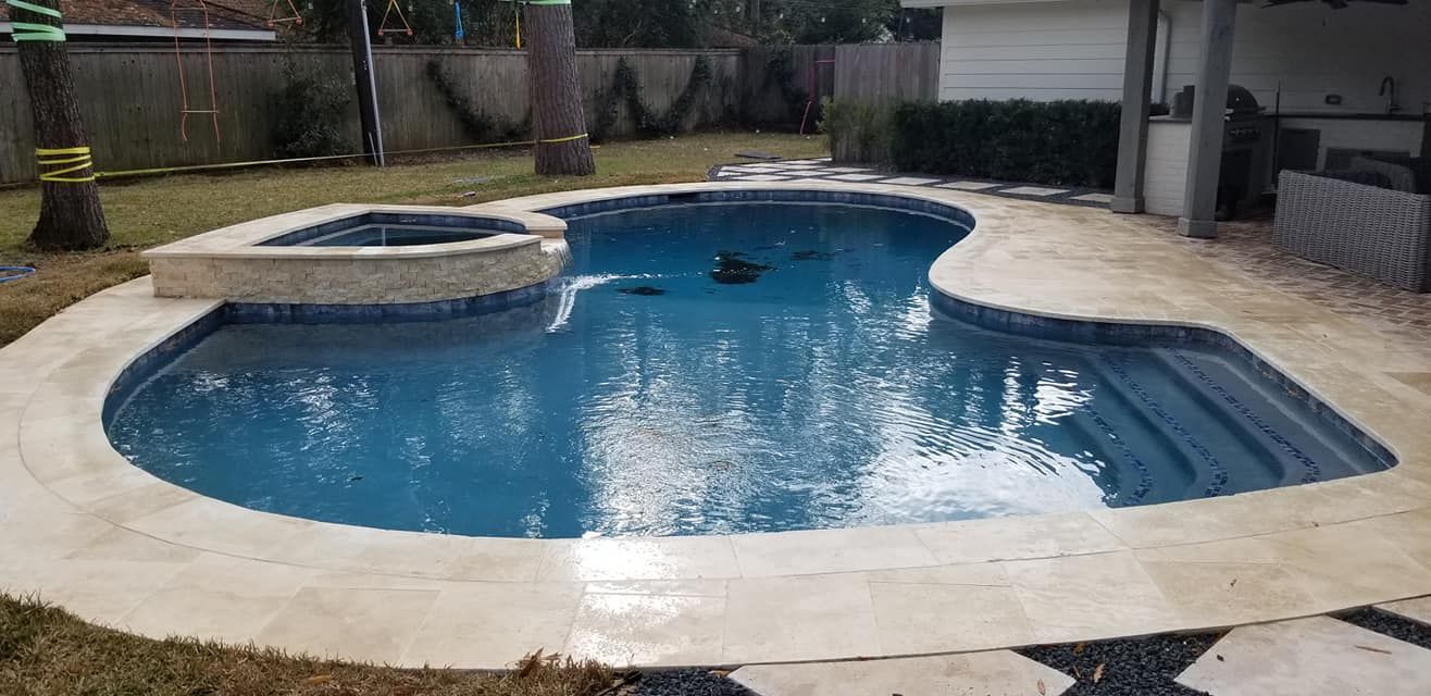 A large swimming pool with a hot tub in the backyard of a house.