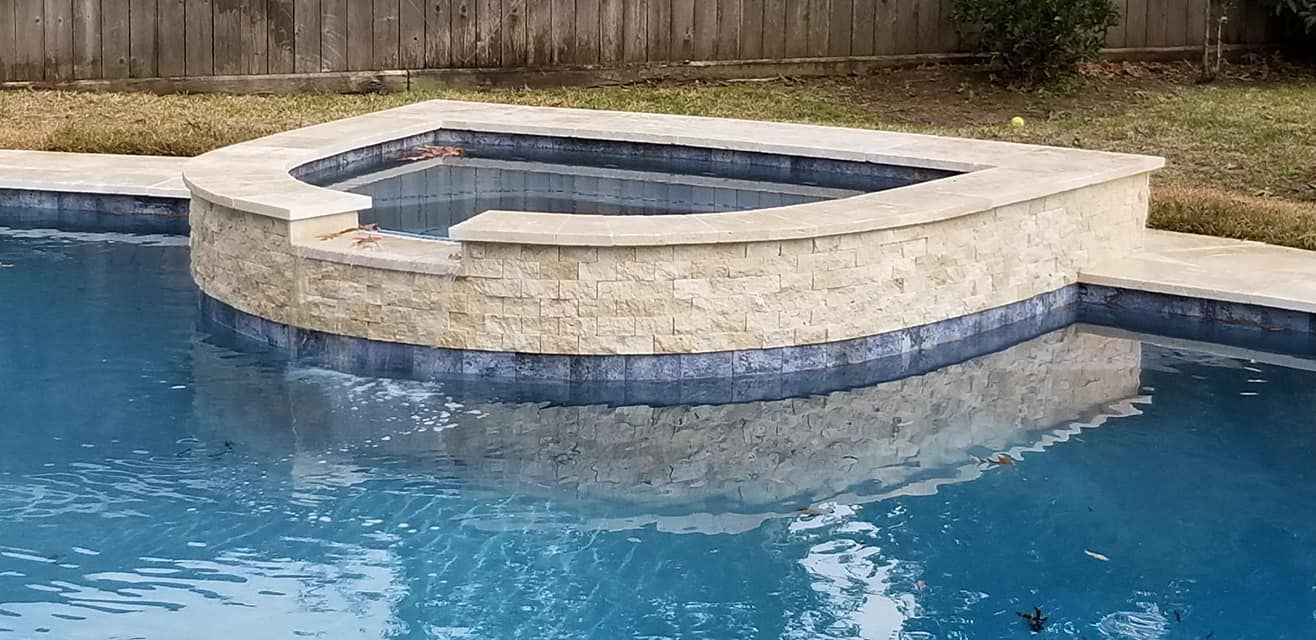 A swimming pool with a hot tub in the middle of it.