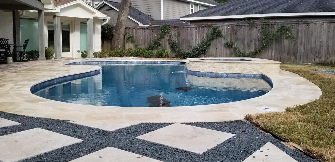 There is a large swimming pool in the backyard of a house.