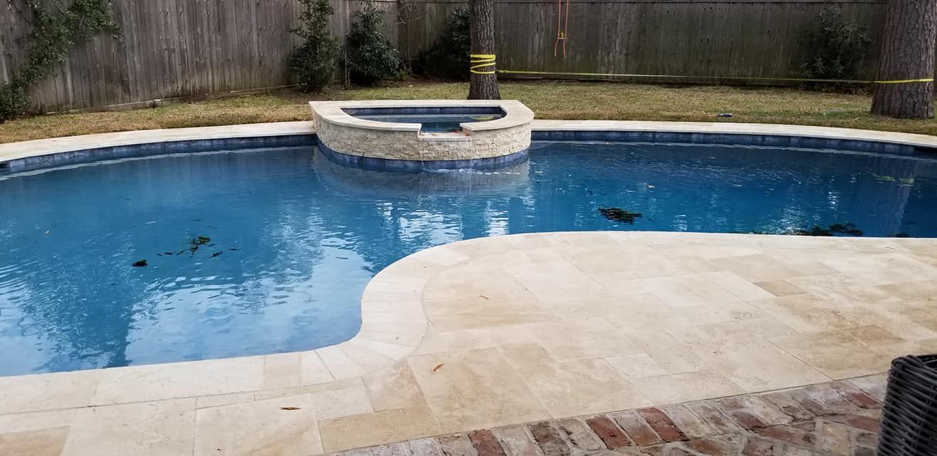 A large swimming pool with a hot tub in the middle of it.