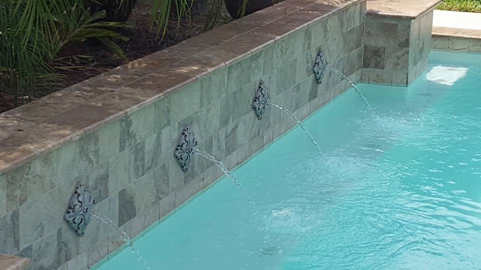 A swimming pool with a waterfall on the side of it.