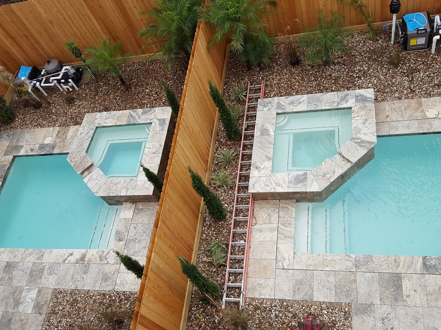 An aerial view of two swimming pools and a hot tub
