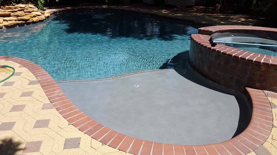 A large swimming pool with a hot tub in the middle