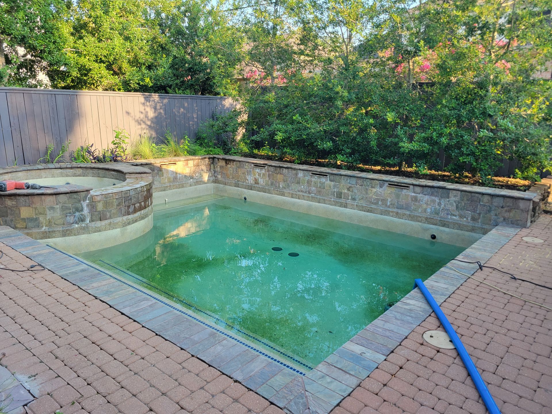 A hose is attached to the side of a swimming pool.