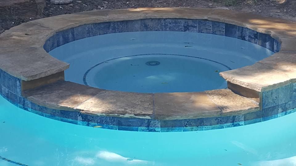 A hot tub is sitting in the middle of a swimming pool.